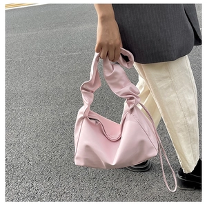 Close-up of pink ruched cloud bag with wide pleated strap and smooth nylon texture