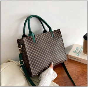 Close-up of vintage pattern tote bag featuring green straps and gold metal hardware