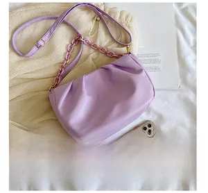 Macro shot of purple ruched cloud bag with acrylic chain and a smartphone for size reference