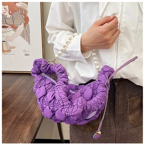 Detail of purple ruched cloud bag featuring elegant white pearl bead handle and texture