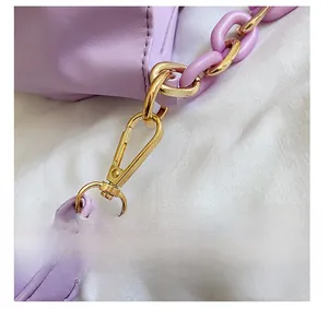 Detail of the golden alloy hook and lavender leather strap on a ruched cloud bag