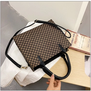 Detailed top view of a brown tote bag with geometric pattern and black leather straps