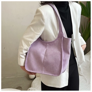 Macro side view of a purple plush tote bag on model shoulder with soft suede texture