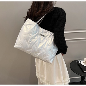 Detailed view of white metallic quilted tote bag with pearl finish and modern style