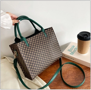 Detail view of vintage tote bag with gold geometric print and dark green leather handles