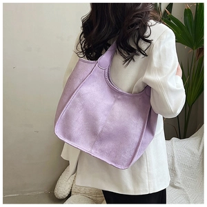 Detail view of large purple suede tote bag showing soft matte texture and minimal stitching