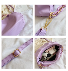Detail view of purple ruched cloud bag showing golden hardware and interior storage space