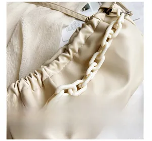 Détail du sac nuage froncé beige avec une large chaîne en acrylique blanc et cuir souple