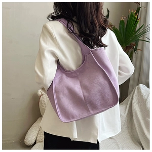 Detailed back view of a large purple plush tote bag showing size and drape on a model