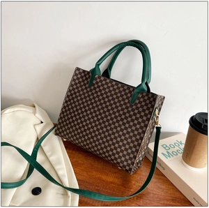 Detail of retro tote bag featuring geometric print and dark green leather handles