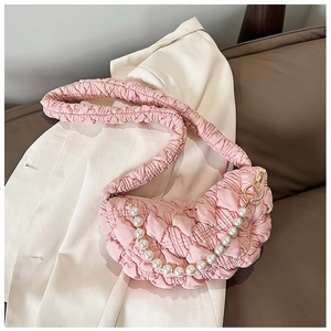 Detail of pink pleated cloud bag featuring soft fabric texture and elegant pearl handle