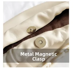 Détail macro du sac en cuir crème avec boucle magnétique en métal et chaîne acrylique