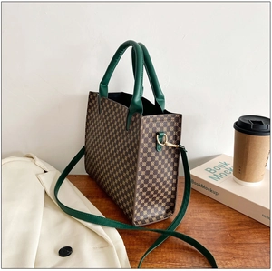 Detailed view of the dark brown printed tote bag showing side metal hooks and green handles