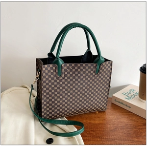 Brown tote bag with geometric pattern and dark green straps on a wooden table