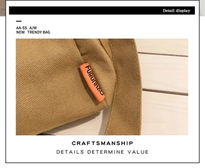 Détail du sac en toile kaki avec étiquette orange et texture tissée sur bois clair