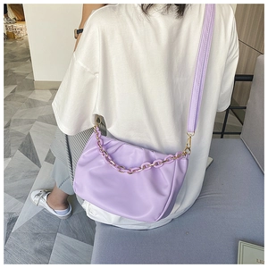 Detail view of purple ruched cloud bag with matching chain and adjustable strap