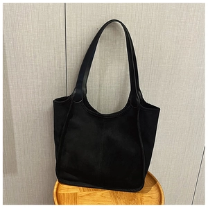 Detail of the soft matte texture and vertical stitching on this black plush tote bag