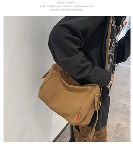 Détail du sac bandoulière en toile kaki avec tissu résistant et étiquette orange