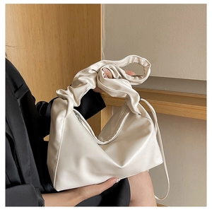 Close-up of cream pleated shoulder bag with soft cloud handle and smooth PU leather texture