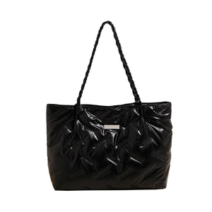 Glossy black quilted puffer tote bag with woven shoulder straps and metallic logo
