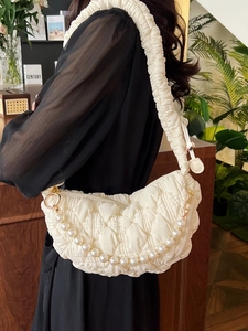 Quilted white half-moon underarm bag with pearl chain and elegant gold hardware