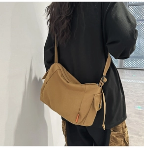 Vue arrière d'un mannequin portant une besace en toile marron avec bandoulière réglable