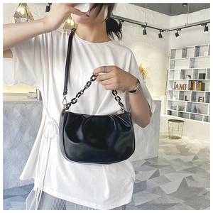 Detailed close-up of the black pleated leather cloud bag with gold chain strap