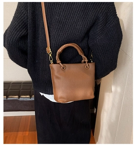 Detailed close-up of brown vertical pleated texture on a retro bucket bag with gold hardware