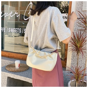 Detail of cream pleated cloud bag showing soft leather texture and acrylic chain strap