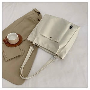 Detail view of the off-white nylon tote bag with front pocket and chic metal hardware