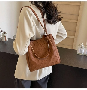 Close-up of quilted tote bag with metallic handles and elegant silver bottom studs