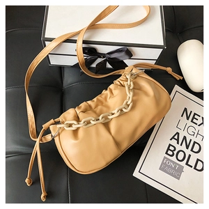 Gros plan du sac nuage plissé jaune avec chaîne épaisse et texture en cuir PU souple