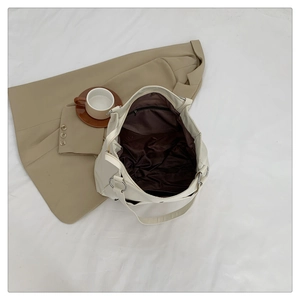 Detailed view of the spacious inner compartment with zipper pocket on beige tote bag