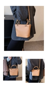 Detail view of vertical pleated texture and golden hardware on khaki bucket bag