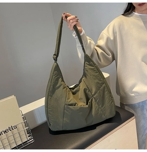 Detail view of the olive green nylon tote bag featuring durable fabric and adjustable strap