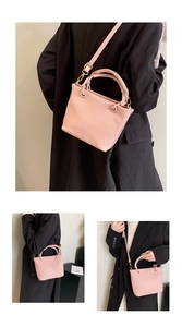 Detail of pink pleated bucket bag with vertical textures and gold hardware accents