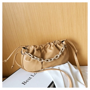 Détail du sac nuage beige plissé avec chaîne en acrylique et texture cuir souple