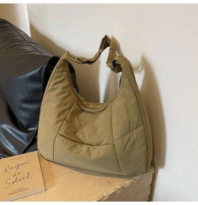 Quilted nylon hobo bag in khaki green on a stone surface with high-end texture detail