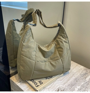 Detailed view of khaki quilted puffer hobo bag with zip closure and wide shoulder strap