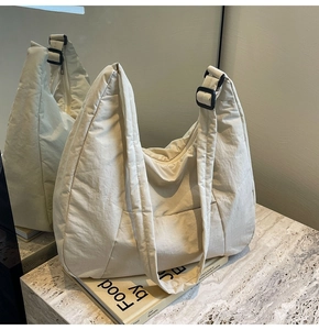 Detail of cream nylon quilted hobo bag with adjustable strap and smooth zipper closure