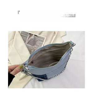 Internal view of the denim crossbody bag showing multi-compartment storage space