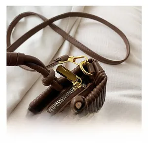 Detailed shot of vertical pleated brown leather with premium golden metal hardware
