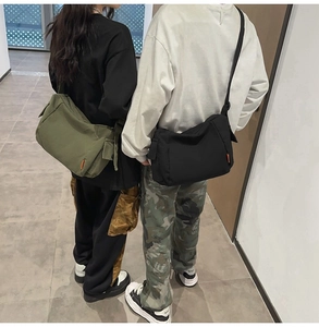 Détail montrant les grands sacs à bandoulière en toile en vert armée et noir