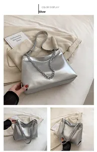 Detailed view of silver metallic textured leather bag with chunky chain strap and long strap