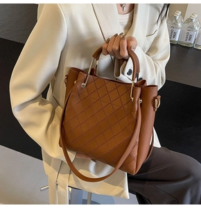 Close-up of brown leather bucket bag featuring quilted stitching and gold hardware details