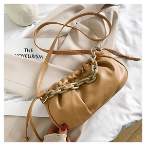 Détail du sac nuage froncé caramel avec une épaisse chaîne en résine crème