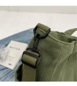 Detail of green corduroy tote bag showing adjustable strap and textured fabric