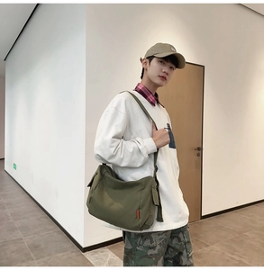 Vue détaillée du sac bandoulière en toile vert armée porté en travers par un mannequin