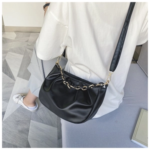 Detail view of black pleated cloud bag with metallic chain and leather shoulder strap
