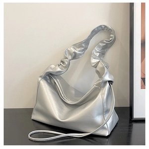 Detail of silver pleated cloud bag with metallic finish and ruffled shoulder strap